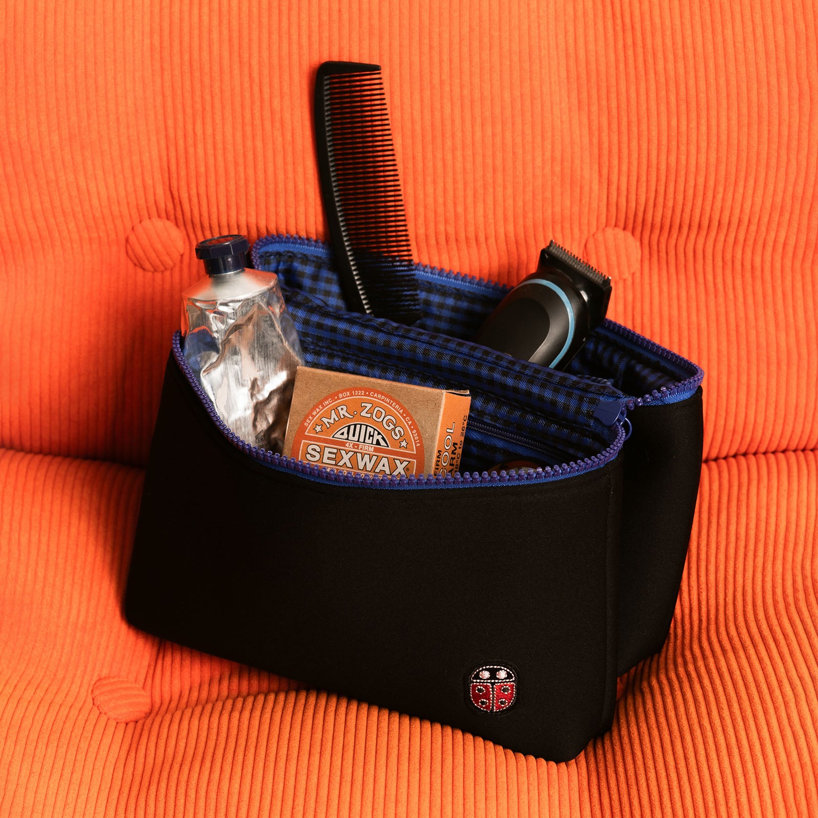 Trousse de toilette TWIN Surf Medium sur un fauteuil – par Venitee Family